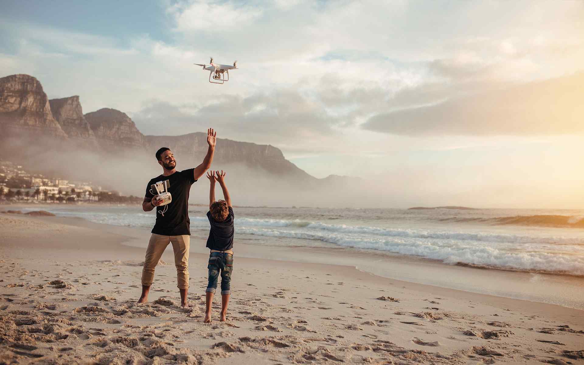 man is flying drone with his son